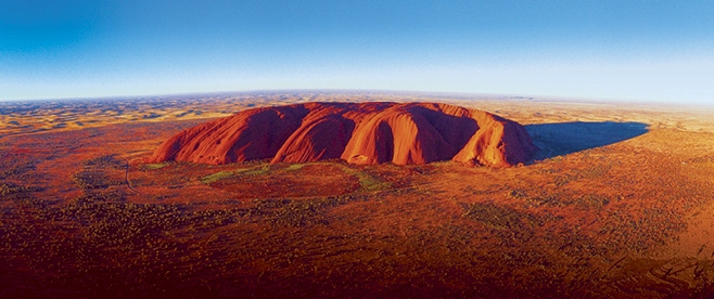 Aboriginal guide leading a Dreamtime walk near Uluru during an authentic aboriginal experiences Australia tour