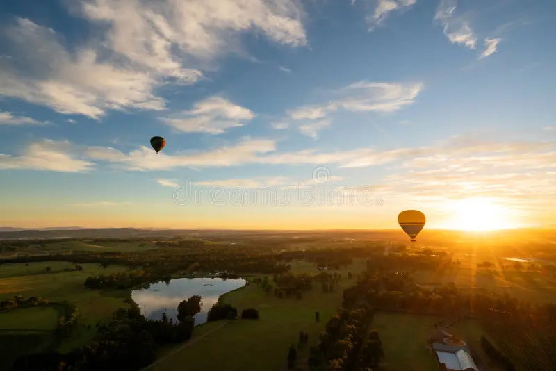 Hot air balloon Australia flying at sunrise over scenic landscapes