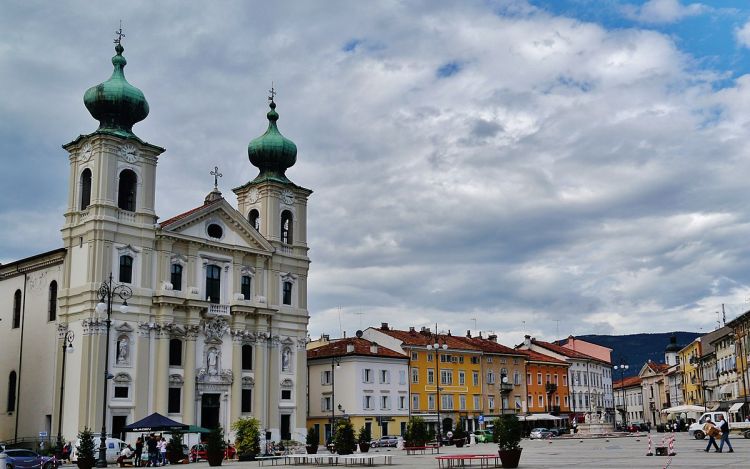Gorizia Italy travel guide – panoramic view of Gorizia’s medieval castle, red-tiled rooftops, and surrounding hills under a golden sunset