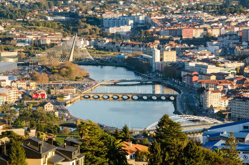 Pontevedra Spain travel guide – late afternoon view of Pontevedra Old Town with stone arcades, historic church towers, and soft golden light over a quiet plaza